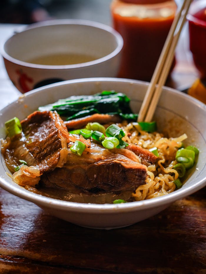 Delicious and authentic Indonesian beef noodle soup with fresh greens and flavorful broth.