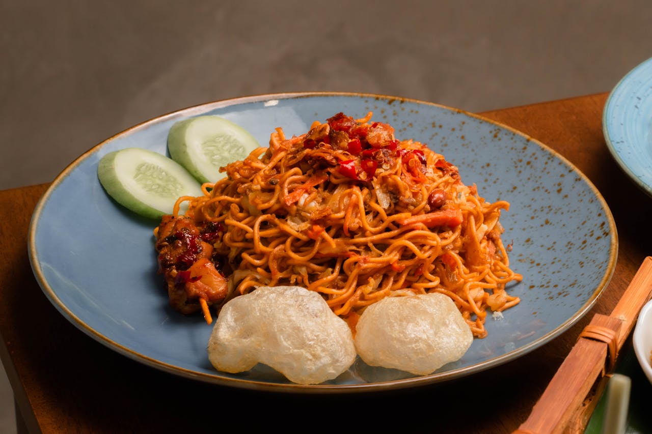 Delicious spicy noodles served with satay chicken and side of fresh cucumber and crackers.